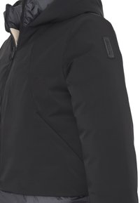 Giacca invernale nera con cappuccio, apertura con zip e patch logo sulla manica superiore, mostrata da un lato del busto.