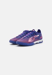 Scarpe sportive con una tomaia in mesh traspirante nei colori viola e rosa, con suola in gomma e dettagli bianchi a contrasto. Design con lacci per una vestibilità sicura.