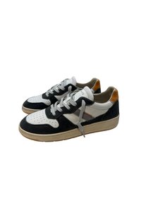 Sneaker con tomaia in camoscio nero e pelle bianca, lacci grigi e suola in gomma colorata. Dettagli includono cuciture arancioni e passante sul tallone.