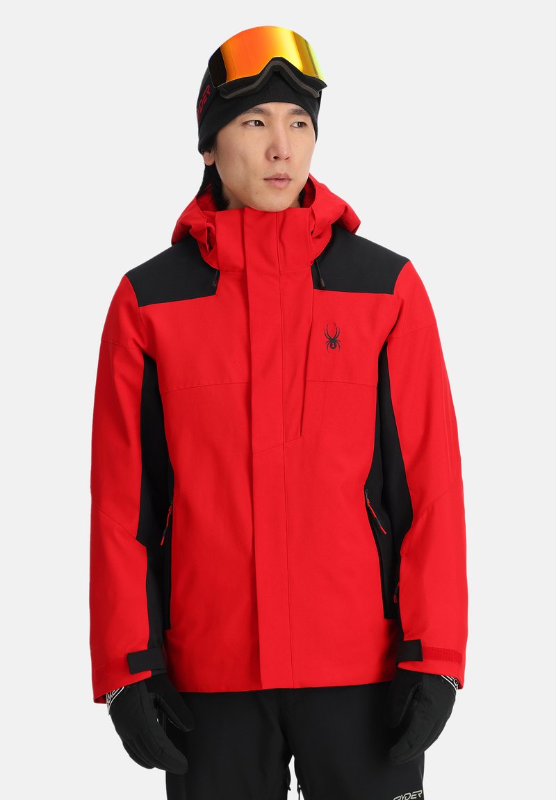 Giacca da sci rossa e nera con cappuccio, tasche con cerniera e logo Spider. Realizzata in materiale resistente alle intemperie con una texture liscia.