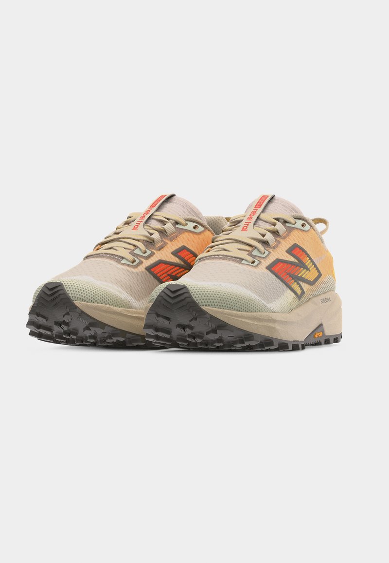 Par de zapatillas para correr por senderos en beige y naranja con suelas gruesas negras con dibujo y logo rojo en los costados, fotografiadas sobre un fondo blanco.