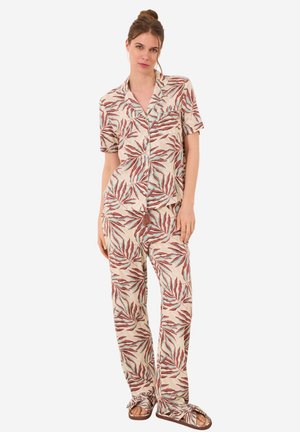 Completo pigiama a maniche corte in tessuto leggero con stampa a foglia in tonalità di rosso e verde acqua, composto da una camicia con bottoni e pantaloni larghi.