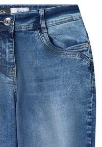 Jean en denim bleu avec fermeture par bouton, poches avant et poche pièce, et effet délavé au niveau des cuisses.