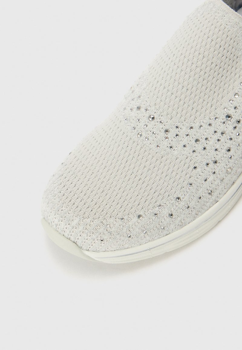 Hellgraue Sneakers mit strukturiertem Strick-Obermaterial und funkelnden Akzenten. Runde Zehenpartie, flexible Sohle und dezente Schimmerelemente überall.
