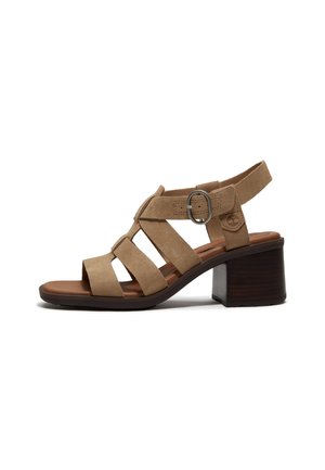 Sandalo aperto in camoscio marrone con tacco a blocco, più cinturini e fibbia regolabile sulla caviglia.