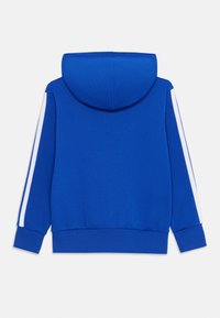 Felpa blu con tessuto a trama, caratterizzata da un grande cappuccio e strisce bianche sui lati delle maniche. Vestibilità classica e design cropped.