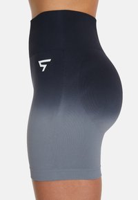 Shorts de rendimiento de cintura alta en un degradado de azul marino oscuro a gris claro, con una tela suave y elástica y un pequeño acento del logo en blanco.