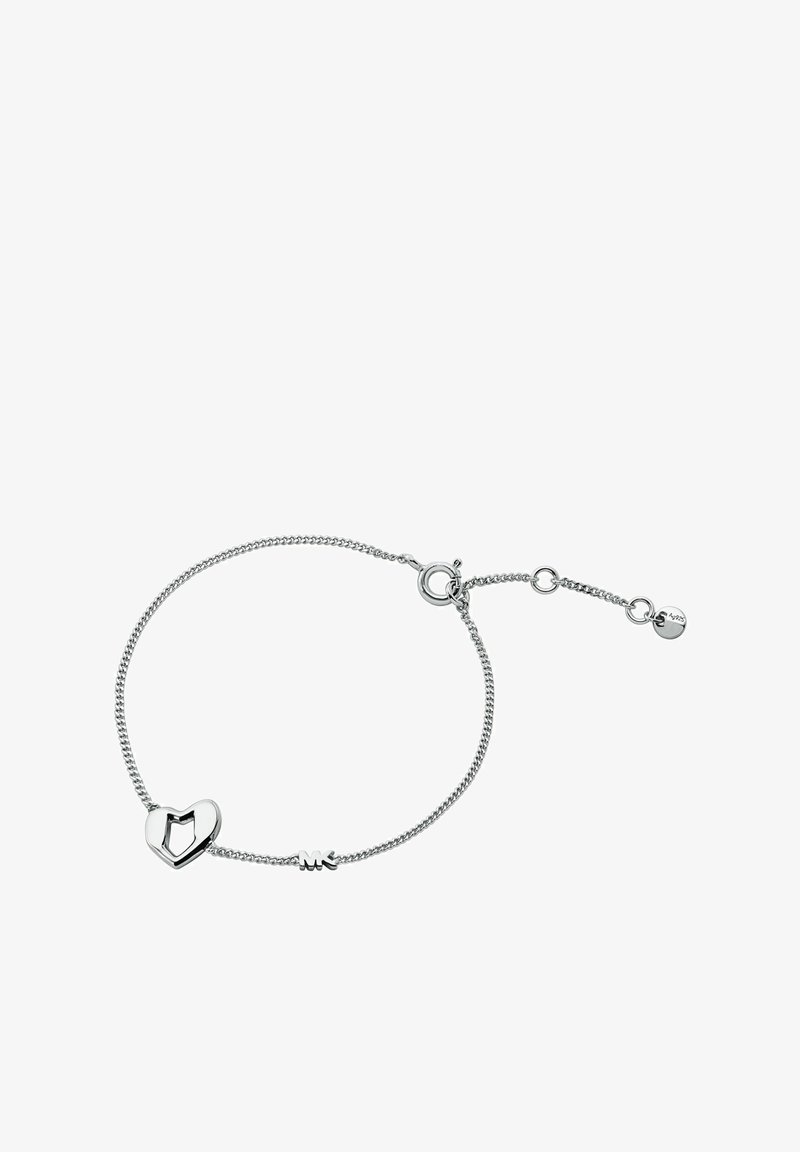 Pulsera de plata con un charm en forma de corazón que presenta detalles troquelados y un pequeño logo grabado. Cadena ajustable para variar el tamaño.