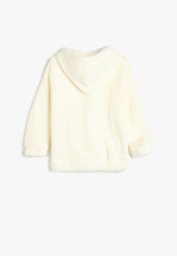 Veste à capuche floffy de couleur crème, avec des manches longues, un ourlet arrondi et une texture douce, conçue pour le confort et la chaleur.