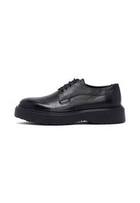Zwarte leren veterschoenen met een gestructureerde afwerking en een dikke rubberen zool, voorzien van opvallende stiksels en een ronde neus.