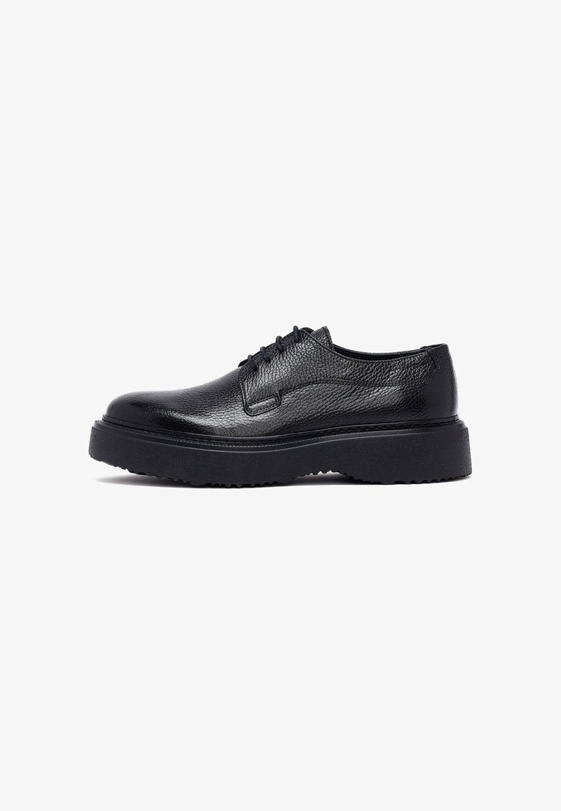 Chaussures noires en cuir à lacets avec une finition texturée et une épaisse semelle en caoutchouc, présentant des coutures saillantes et un design à bout arrondi.