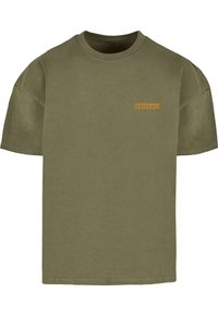 Oliven grøn bomulds T-shirt med rund hals og korte ærmer; har små gule skrifter på venstre brystområde. Enkel design, ingen mønstre.