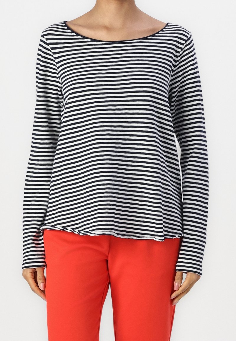 Zwart-witte gestreepte langemouwtop, scoop halslijn, vloeiende silhouet, gecombineerd met felrode broeken, zachte stof, casual stijl.