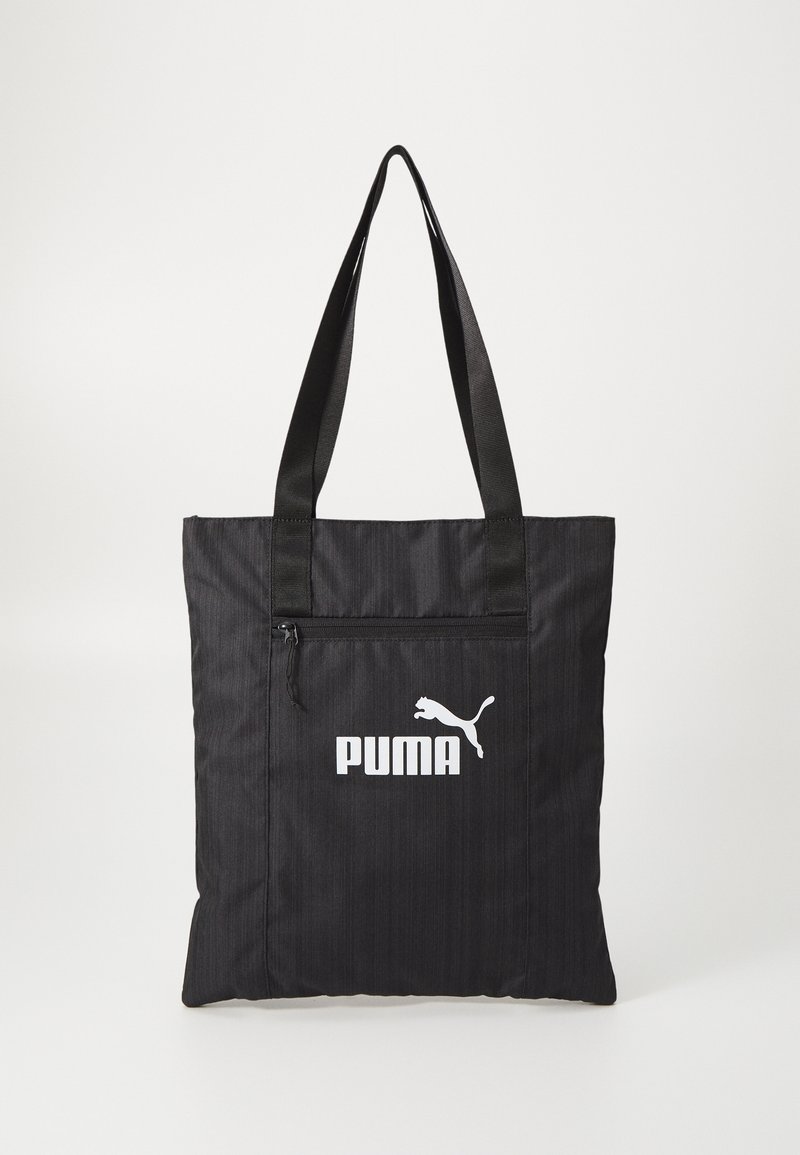 Sac cabas noir Puma avec longues anses, poche avant zippée et logo Puma blanc sur fond clair uni.
