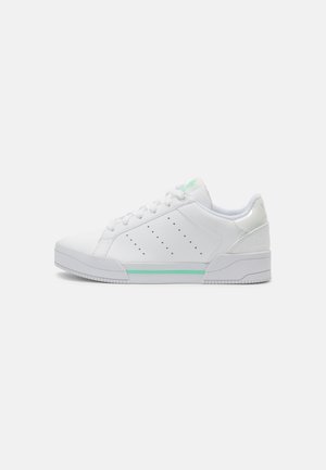 White low-top sneakers with a smooth leather finish, perforated design accents, mint green stripe, and textured rubber sole.