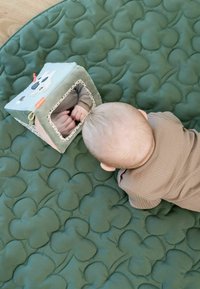 Pehme roheline vatitatud mängumatiga, millel on välja kõrgendatud pilvemustrid. Lähimusel asub pehme mängumaja peegliga ning värvikate detailidega, peegeldades lapse käsi.