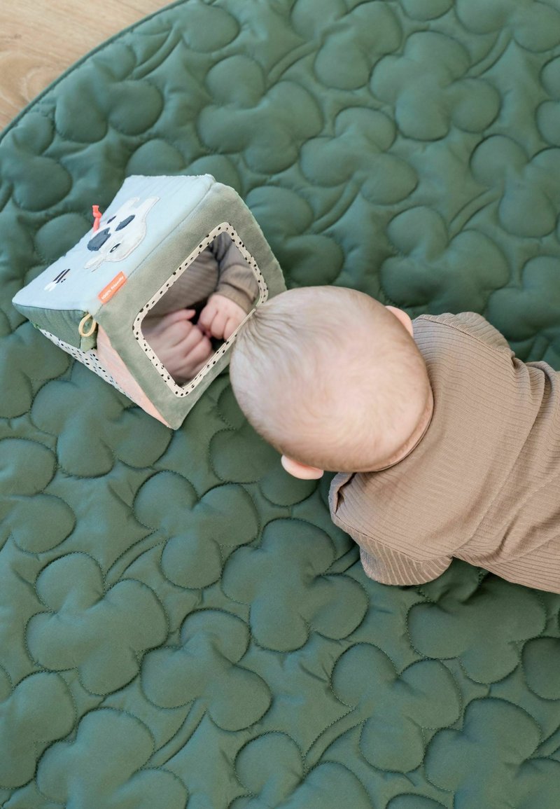 Pehme roheline vatitatud mängumatiga, millel on välja kõrgendatud pilvemustrid. Lähimusel asub pehme mängumaja peegliga ning värvikate detailidega, peegeldades lapse käsi.