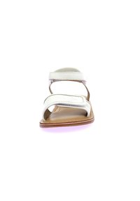 Sandalias planas blancas con dos correas ajustables, textura suave y suela marrón. Diseño simple con hardware minimal y punta abierta.