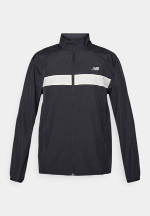 Fekete széldzseki elülső cipzárral, magas gallérral és fehér vízszintes csíkkal a mellkasnál. Tartalmazza a New Balance logót.