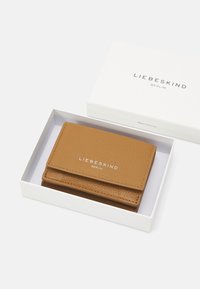 Braune Leder-Geldbörse mit strukturiertem Finish, ausgestattet mit einem Klappdesign und eingeprägtem "LIEBESKIND BERLIN"-Logo, geliefert in einer weißen Box.