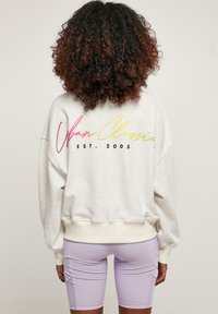 Sudadera gris de corte holgado, con un diseño vibrante de "Urban Classic" en colores arcoíris y el texto "EST. 2005" en la parte posterior.