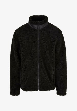 Sort fleecejakke med en struktureret, højt pileoverflade, stående krave, fuld lynlås og sidelommer. Har en glat skulderpanel.