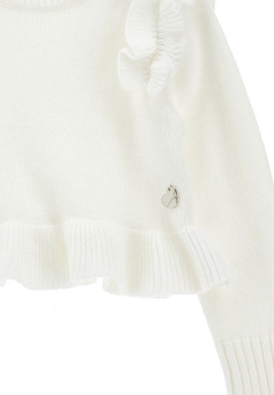 Maglione bianco a maglia con orlo a coste, caratterizzato da un accento arricciato su una spalla e un piccolo logo a forma di cuore argentato vicino al fondo.
