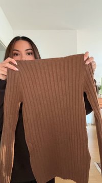 Bruine geribbelde trui met lange mouwen van zachte stof, voorzien van een aansluitend ontwerp en een licht gebogen zoom aan de onderkant.