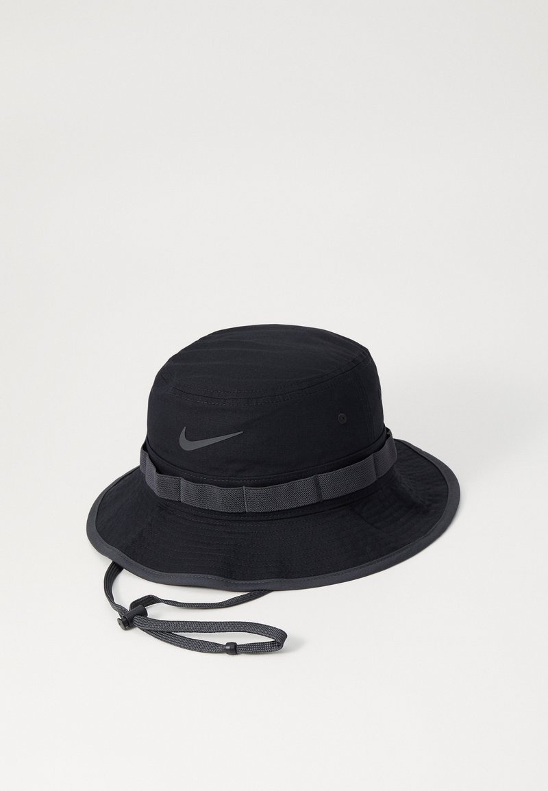 Chapeau seau noir en tissu léger, avec un large bord, une sangle de menton ajustable et un logo Nike réfléchissant discret à l'avant.