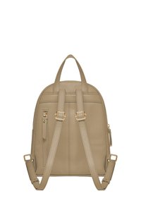 Pequeña mochila de cuero beige con dos correas de hombro ajustables, un asa superior y un bolsillo con cremallera vertical en la parte posterior.
