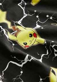 Svart tyg med Pikachu-illustrationer och blixtmönster. Klara gula, röda och vita färger; mjuk textur med en lekfull design.