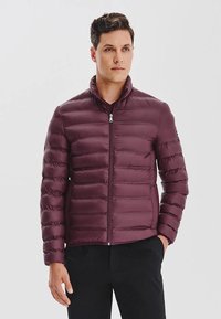 Burgundowa kurtka puchowa z zamek błyskawicznym z przodu, stójką i poziomym pikowaniem. Gładka, lekka tkanina i dopasowany krój.