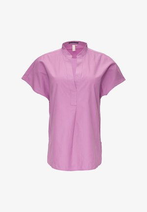 Jasnoróżowa bluzka z krótkim rękawem i kołnierzykiem mandarynkowym, z przodem zapinanym na guziki i luźnym krojem. Wykonana z gładkiej bawełny.