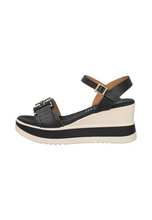 Sandalia de cuña de cuero negro con correa en el tobillo y hebilla, suela beige y negra con plataforma, diseño de punta abierta.