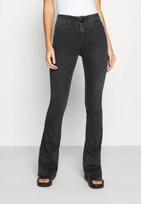 Svarta utsvängda jeans i ett stretchigt denimtyg, med framknäppning och dragkedja, fem fickor och en stilren finish.