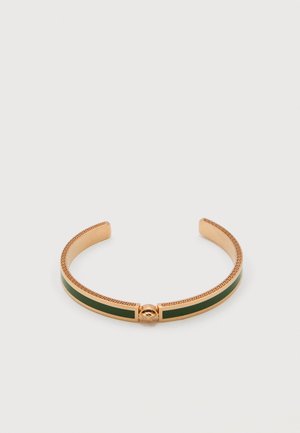 Gold cuff bracelet with dark green enamel inlay and intricate Greek key pattern along edges, open-ended design, centered medallion detail.