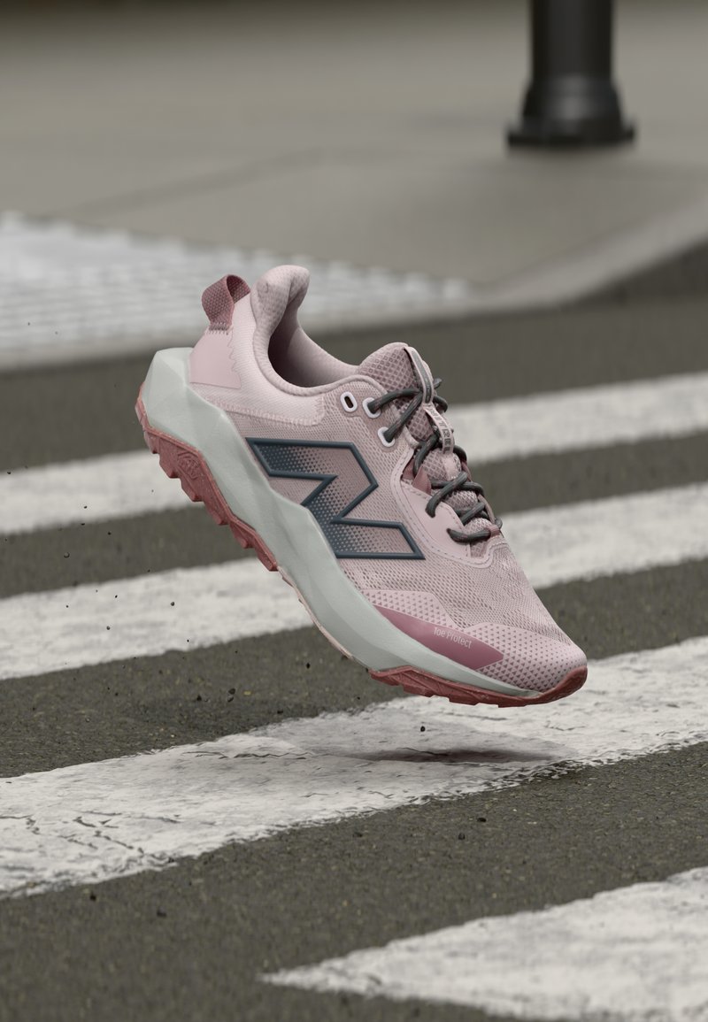 Gaiši rozā skriešanas apavi ar tīkla virsu, pelēkiem akcentiem un teksturētu zoli. Ir mīkstināta vidējā zolīte un pastiprināts pirkstu aizsargs.