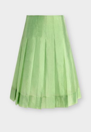 Φυστικί πλισέ μίντι φούστα με φαρδιά ραφή, κατασκευασμένη από γυαλιστερό, λείο ύφασμα, εμφανίζεται σε απλό ανοιχτογρί φόντο.