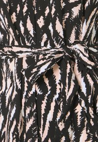 Robe noire avec un motif abstrait rose et blanc. Elle présente une taille cintrée à nouer et une texture plissée. Tissu doux avec un design fluide.