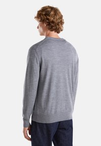 Maglione grigio con scollo tondo, polsini e orlo a coste. Tessuto in misto lana con una texture liscia, mostrato da dietro.