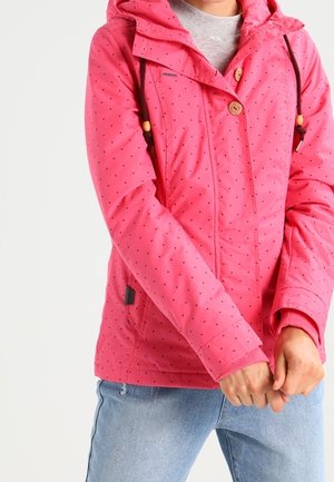 Pink insulated jacket with a hood, featuring black polka dots, wooden buttons, and ribbed cuffs. Two side pockets are visible.