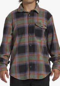 Flanellen shirt in een geruit patroon met groene, zwarte en oranje kleuren. Voorzien van een knoopsluiting, lange mouwen en een borstzak.