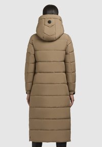 Lange, gevoerde jas in beige met een capuchon, voorzien van horizontale stiknaad en een ronde logo-accent op de rug. Gladde textuur en warm ontwerp.