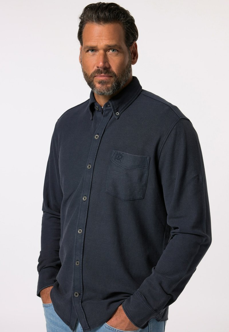 Camicetta a manica lunga blu navy realizzata in cotone testurizzato, con colletto button-down, taschino sul petto e un discreto dettaglio del logo.