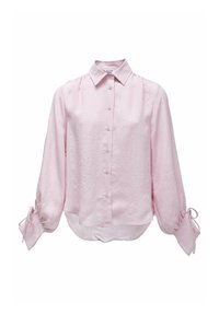Camisa de botones de color rosa claro con mangas largas y fruncidas que tienen lazos en los puños. La tela tiene un patrón texturizado.