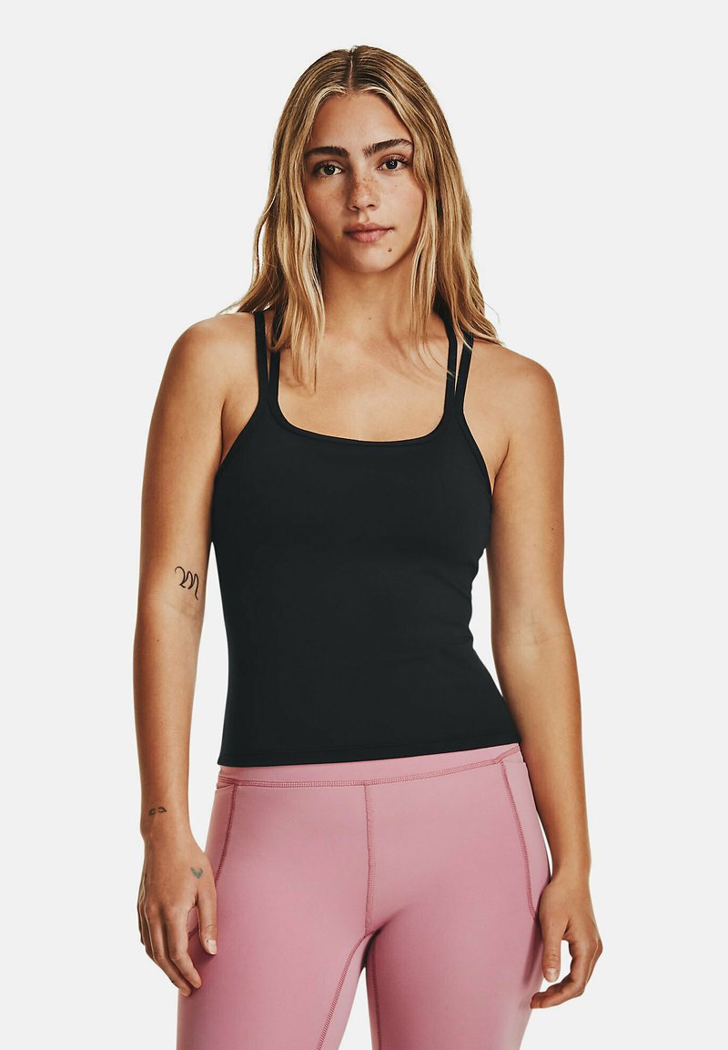 Schwarz eng anliegendes Tanktop mit dünnen Trägern und quadratischem Ausschnitt, kombiniert mit rosa hochtaillierten Leggings. Glattes Material, minimalistisches Design.