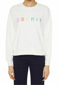Sudadera blanca con un corte boxy, que presenta un logo "ESPRIT" multicolor en el pecho. Textura suave y puños acanalados en las mangas y el dobladillo.