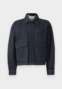 Mørkeblå denimjakke med spiss krage, skjulte frontknapper og to store klafflommer foran.
