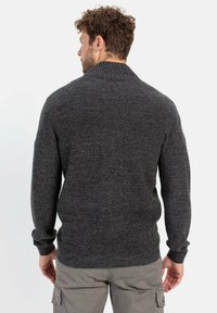 Dunkelgrauer Strickpullover mit geripptem Kragen und Bündchen sowie einem strukturierten Muster. Die Passform ist lässig und an der Taille leicht tailliert.