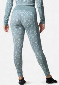 Gevoerde lichtblauwe leggings met een wit sneeuwvlok- en geometrisch patroon. Inclusief een aansluitende tailleband en enkelmanchetten.